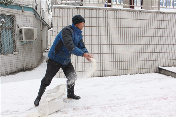 总务处老师洒融雪剂.jpg 总务处老师洒融雪剂.jpg