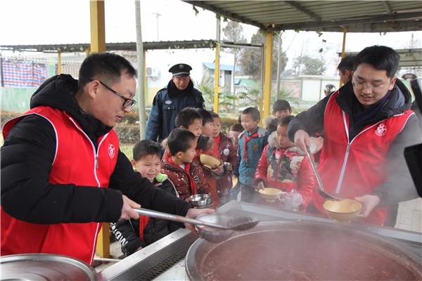 5志愿者们为孩子们盛粥.jpg 5志愿者们为孩子们盛粥.jpg