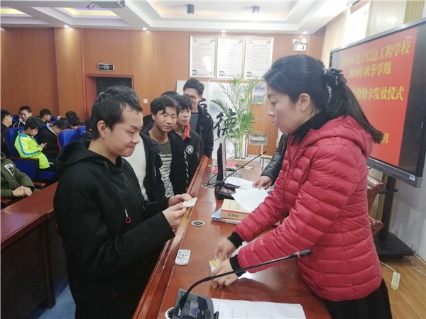 7张丽君主任核对信息并将资助卡发放给学生.jpg 7张丽君主任核对信息并将资助卡发放给学生.jpg