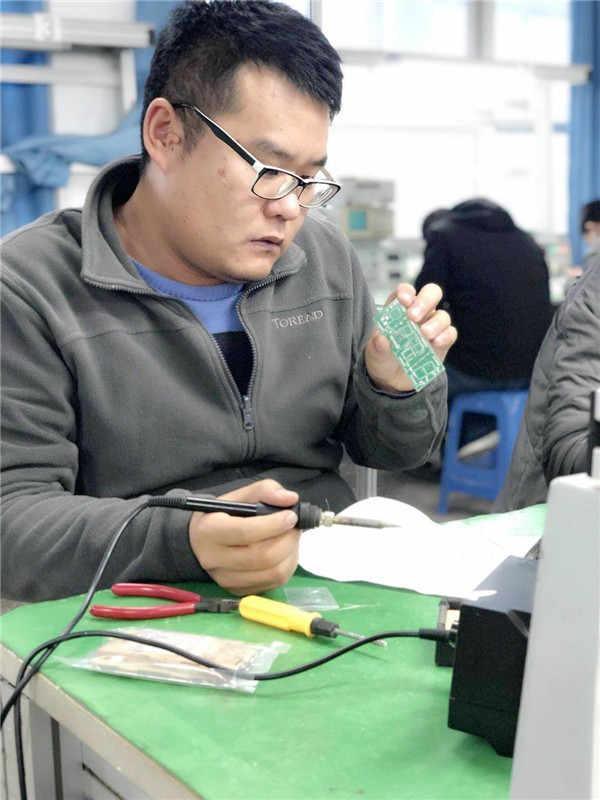 陈文龙老师仔细研究电路板.jpg 陈文龙老师仔细研究电路板.jpg