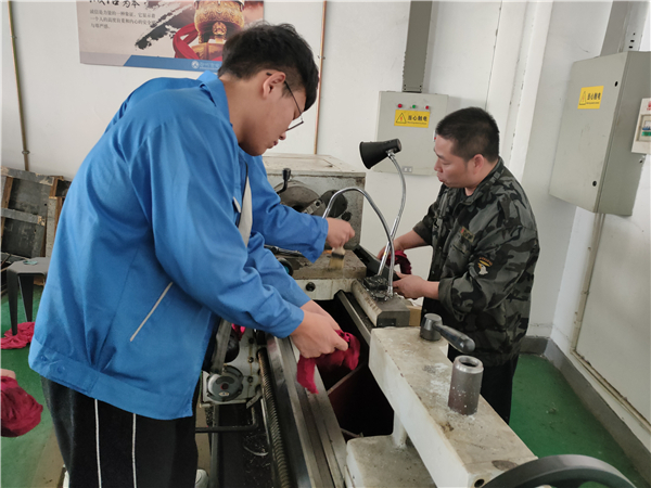 1田师傅带领学生完成车床设备保养.jpg