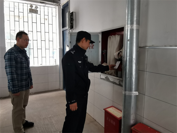 图为郭警官检查学校消防设施.jpg 图为郭警官检查学校消防设施.jpg